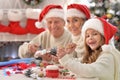 Happy prandparents with grandchild preparing for Christmas together Royalty Free Stock Photo