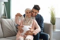 Portrait of happy pregnant muslim couple looking at tiny baby shoes