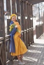 Portrait of a happy pregnant woman with a bouquet of yellow tulips on a walk in spring.