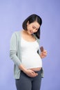 Portrait of happy pregnant woman with chocolate bar standing over purple Royalty Free Stock Photo