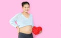 Portrait of happy pregnant woman holding red heart pillow at tummy isolated on pink background with copy space Royalty Free Stock Photo