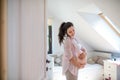 Portrait of happy pregnant woman indoors at home, touching her belly. Royalty Free Stock Photo