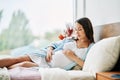 Portrait of happy pregnant woman relax lying in bed and touching her belly at home. Royalty Free Stock Photo