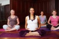 Portrait of happy pregnant women in yoga with leader or teacher teaching in training or class for fitness and meditation Royalty Free Stock Photo