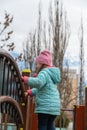Portrait of a happy preschool child on the playground. A five-year-old girl standing holding onto a wooden railing. Childhood. Royalty Free Stock Photo