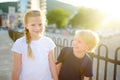 Portrait of a happy preteens girl and boy on a city street during a summer sunset. Friends are walking together. First love