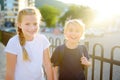 Portrait of a happy preteens girl and boy on a city street during a summer sunset. Friends are walking together. First love