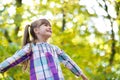 Portrait of happy pretty child girl having fun in autumn forest. Positive female kid enjoying warm day in fall park Royalty Free Stock Photo