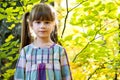 Portrait of happy pretty child girl having fun in autumn forest. Positive female kid enjoying warm day in fall park Royalty Free Stock Photo