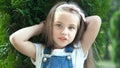 Portrait of happy pretty child girl standing in summer park looking in camera