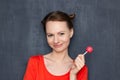 Portrait of happy pretty girl holding pink lollipop in hand Royalty Free Stock Photo