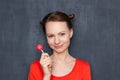 Portrait of happy pretty girl holding pink lollipop in hand Royalty Free Stock Photo