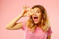 Portrait of a happy pretty girl holding sweet candy over pink ba Royalty Free Stock Photo