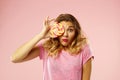 Portrait of a happy pretty girl holding sweet candy over pink ba Royalty Free Stock Photo