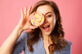 Portrait of a happy pretty girl holding sweet candy over pink ba Royalty Free Stock Photo