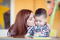 Portrait of happy pretty mother with her toddler son drawing Royalty Free Stock Photo