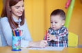 Portrait of happy pretty mother with her toddler son drawing Royalty Free Stock Photo