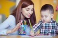 Portrait of happy pretty mother with her toddler son drawing Royalty Free Stock Photo