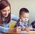 Portrait of happy pretty mother with her toddler son drawing Royalty Free Stock Photo