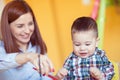 Portrait of happy pretty mother with her toddler son drawing Royalty Free Stock Photo