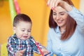 Portrait of happy pretty mother with her toddler son drawing Royalty Free Stock Photo