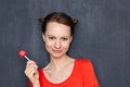 Portrait of happy pretty woman holding pink lollipop in hand Royalty Free Stock Photo