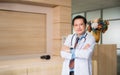 Portrait of happy professional asian man doctor standing and arms crossed with looking at camera in hospital Royalty Free Stock Photo