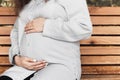 Portrait of a happy and proud pregnant woman by the river in the city. Woman in the light blue shirt. Royalty Free Stock Photo