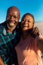 Portrait of happy retired african american senior couple enjoying together at beach Royalty Free Stock Photo