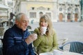 Portrait of happy romantic couple with age difference drinking coffee in cafe with terrace outdoors in the ancient city Royalty Free Stock Photo