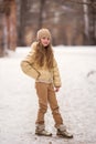 Portrait Of Happy Russian Little Girl In On Background Of Melting Snow In Park In Spring. Child Walking Outdoors