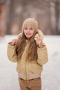 Portrait Of Happy Russian Little Girl In On Background Of Melting Snow In Park In Spring Close Up. Child Walking Outdoors