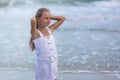 Portrait of a happy Russian little girl in a white dress on a background of the sea. The child walks in the fresh air. Vacation