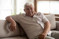 Portrait of happy 80s retired man, sitting on couch at home. Royalty Free Stock Photo