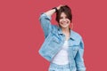 Portrait of happy satisfied beautiful brunette young woman with makeup in denim casual style standing, posing and looking at Royalty Free Stock Photo