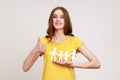 Portrait of happy satisfied female of young age holding paper family chain and showing thumb up Royalty Free Stock Photo