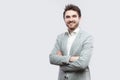 Portrait of happy satisfied handsome bearded man in white shirt, casual grey suit standing, crossed hands and looking at camera Royalty Free Stock Photo