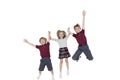 Portrait of happy school children holding hands while jumping over white background Royalty Free Stock Photo