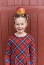Portrait of a happy school girl with red apple on head. Farewell Bell. day of knowledge. beginning of the school year Royalty Free Stock Photo