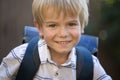 Portrait of a happy schoolboy. cute smart cheerful pupil with a school backpack behind his back