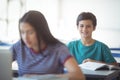 Portrait of happy schoolboy studying in classroom