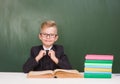 Portrait of a happy schoolboy in a suit near empty green chalkboard Royalty Free Stock Photo