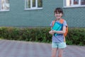 Portrait of happy schoolgirl with backpack and notebooks