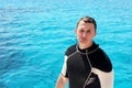 Portrait of happy scuba diver. Man is preparing for his diving lesson in the blue sea