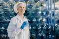 portrait happy senior adult caucasian women worker work in drinking water plant factory with clean drink water bottle Royalty Free Stock Photo