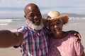 Portrait of happy senior african american couple taking a selfie at the beach Royalty Free Stock Photo
