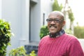 Portrait of happy senior african american man wearing glasses standing outside house, copy space Royalty Free Stock Photo