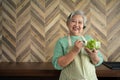 Portrait of happy Senior Asian woman patient eating fresh and clean vegetarian salad in the kitchen at home, cooking healthy food Royalty Free Stock Photo