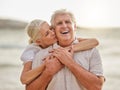 Portrait of a happy senior caucasian couple standing and embracing each other on a day out at the beach. Mature husband Royalty Free Stock Photo