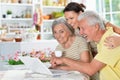 Portrait of happy senior couple with adult daughter using laptop at home, online shopping concept Royalty Free Stock Photo